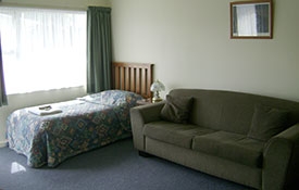 single bed and a couch in the lounge