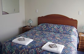 queen-size bed in the room of 1-bedroom unit