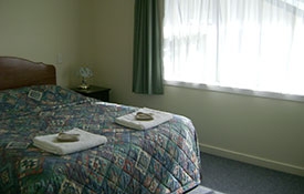 queen-size bed in the main room of 2-bedroom unit